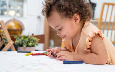 Happy moment little cute girl creating and water color painting activity with paint brushes on...