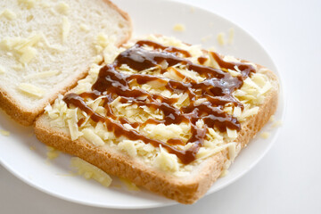Cheese sandwich with brown sauce on a white plate.	