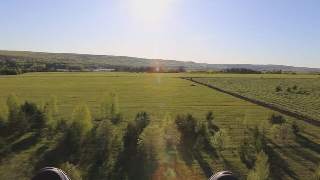 Flight on paraglider over the treetops on a sunny summer day