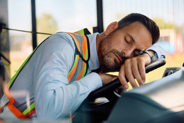 Exhausted bus driver napping in vehicle cabin.