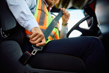 Close up of bus driver fastening seatbelt.