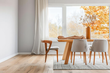 Elegant room interiors in a luxury property with a dinning table next t a large window. Luxury residential Real Estate composition with copy space and plain lighting.