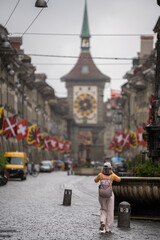 tourist go to travel walk in walking street see old building architecture nation flag and clock tower in Bern Switzerland spring season