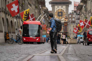 Fototapeta premium tourist go to travel walk in walking street see old building architecture nation flag and clock tower in Bern Switzerland spring season