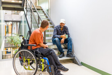 Man in wheelchair talking with a coworker during work break