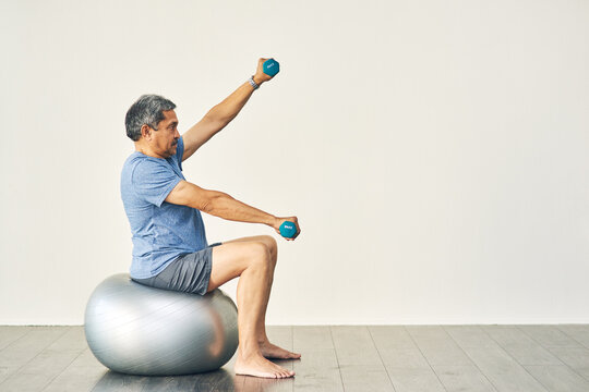 Physiotherapy, senior man and weights for balance, support and exercise and wellness for health or fitness. Pensioner, male person and body ball in recovery, rehabilitation clinic or retirement home