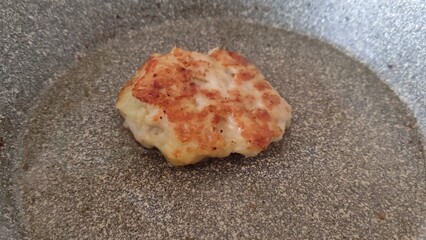 Chopped chicken cutlets are cooked in a frying pan