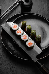 Salmon Maki. Sushi composition on black background. The Art of Japanese Cuisine. Food photography for menu and sushi bar decoration