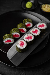 Tuna Maki. Sushi composition on black background. The Art of Japanese Cuisine. Food photography for menu and sushi bar decoration