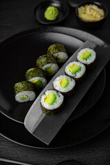 Avocado Maki. Sushi composition on black background. The Art of Japanese Cuisine. Food photography for menu and sushi bar decoration
