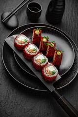 California Masago Roll. Sushi composition on black background. The Art of Japanese Cuisine. Food photography for menu and sushi bar decoration