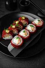 California Masago Roll. Sushi composition on black background. The Art of Japanese Cuisine. Food photography for menu and sushi bar decoration