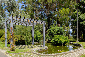 Architectural structure of a gazebo and a small decorative pool in the park.