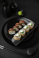 California Unagi Roll. Sushi composition on black background. The Art of Japanese Cuisine. Food photography for menu and sushi bar decoration
