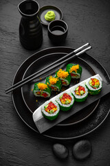 Vegan Roll. Sushi composition on black background. The Art of Japanese Cuisine. Food photography for menu and sushi bar decoration