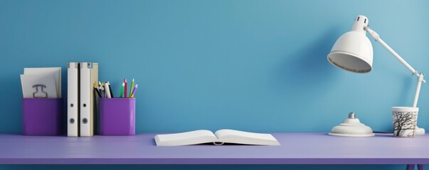 Desk ready for study with a purple holder, a white book, and a classic lamp on a blue wall,