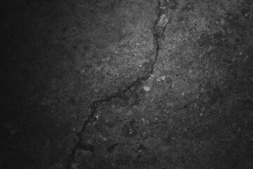 Cracked concrete surface, rough texture, grayscale, scattered light spots, deep fissure running diagonally, small pebbles embedded, high contrast, natural imperfections, weathered appearance, granular