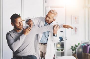 Senior doctor, man and patient with shoulder pain for physical therapy, stretching and body recovery. Orthopedic, physician and medical expert for arm consultation with examination, advice or healing