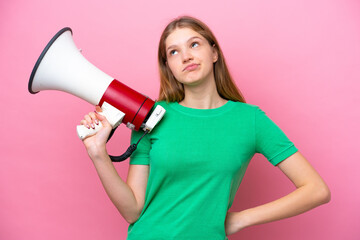 Teenager Russian girl isolated on pink background holding a megaphone and thinking