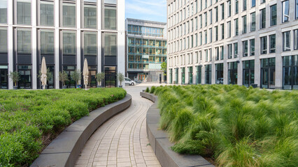 modern urban courtyard featuring a winding pathway lined with greenery and plants