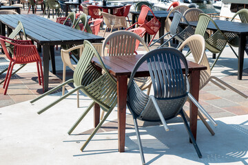 Empty terrace and patio of a closed bar restaurant in sunny day, chairs