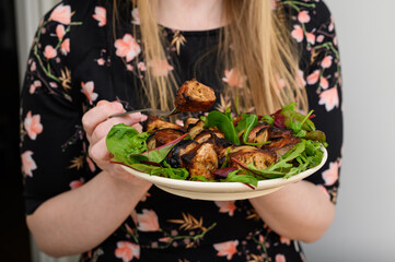 Grillowany szaszłyk z mięsa wieprzowego podany na talerzu z zieloną sałatą 