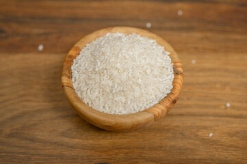 Porcja surowego białego ryżu w drewnianej misce
