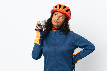 Teenager cyclist woman isolated on white background with fingers crossing and wishing the best