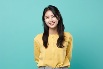 Fototapeta premium A woman in a yellow shirt is smiling and posing for a picture