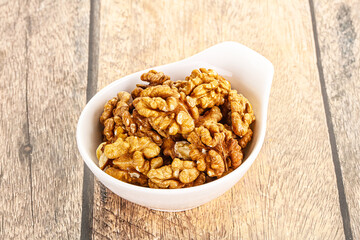Cracked unshelled walnut in the bowl