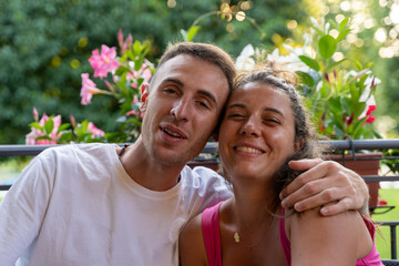 young couple in love having aperitif sitting at a pub table outdoors having fun