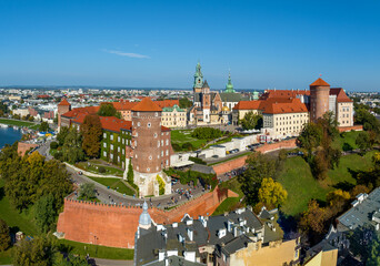 Fototapeta premium Royal Wawel Castle and Gothic Cathedral in Krakow, Poland. Renaissance Sigismund Chapel with golden dome, towers, defensive walls, yard, park and tourists. Vistula river with small harbor. Aerial view