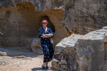Tired woman hiker is standing near a large stone. High quality photo