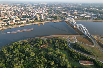 Aerial view of a barge and railway bridge (Zezeljev Most) over the Danube river on sunny day. Novi...