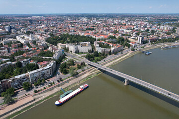 Fototapeta premium Aerial view of Novi Sad, bridge over Danube river and a barge on sunny summer day. Serbia.