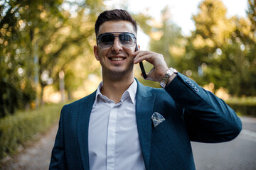 Businessman in Suit and Sunglasses Talking on Cell Phone