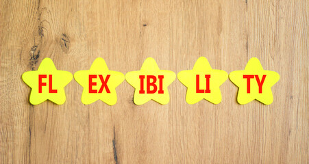 Flexibility symbol. Concept word Flexibility on beautiful yellow paper stars. Beautiful wooden...