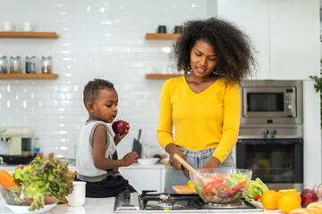 Portrait of enjoy happy love african american family mother and african little boy son child having fun help cooking food healthy eat together with fresh vegetable salad and ingredient in kitchen