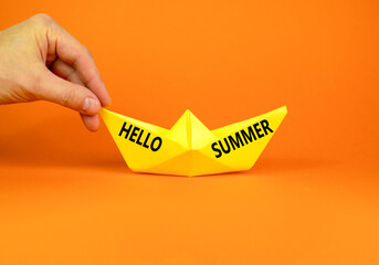 Hello summer symbol. Concept words Hello summer on beautiful yellow paper boat. Beautiful orange paper background. Tourist hand. Business lifestyle Hello summer concept. Copy space.