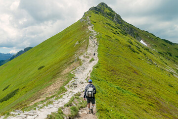 A man is hiking in the mountains. Active recreation in the mountains in summer. Tatra Mountains