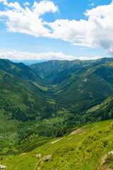 Obraz premium Beautiful mountain landscape in summer. Green grass, high rocks, blue sky and white clouds. Natural background. Tatra Mountains