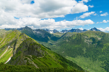 Naklejka premium Beautiful mountain landscape in summer. Green grass, high rocks, blue sky and white clouds. Natural background. Tatra Mountains