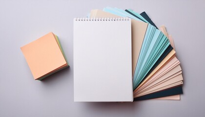 Top view of a blank white paper sheet next to a stack of colorful sticky notes.