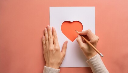 A person's hand drawing a heart shape on a blank white paper sheet.