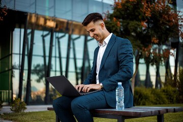 Businessman in Suit Working on Laptop at Bench