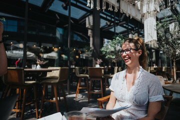 Smiling young woman engaged in a lively discussion during a casual business meeting at a stylish cafe. Natural light and relaxed atmosphere.