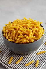 Homemade Raw Dry Gemelli Pasta in a Bowl, side view.