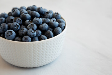 Organic Blueberries in a Bowl on a gray background, side view. Space for text.