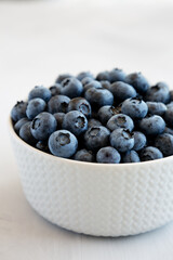 Organic Blueberries in a Bowl on a gray background, low angle view. Close-up.