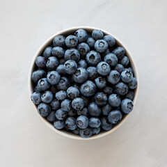 Organic Blueberries in a Bowl on a gray background, top view. Flat lay, overhead, from above.